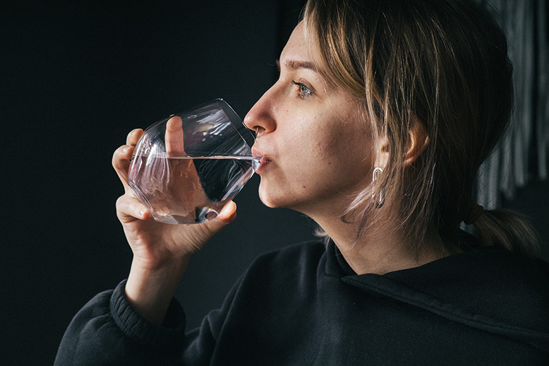 a woman drinking smart water